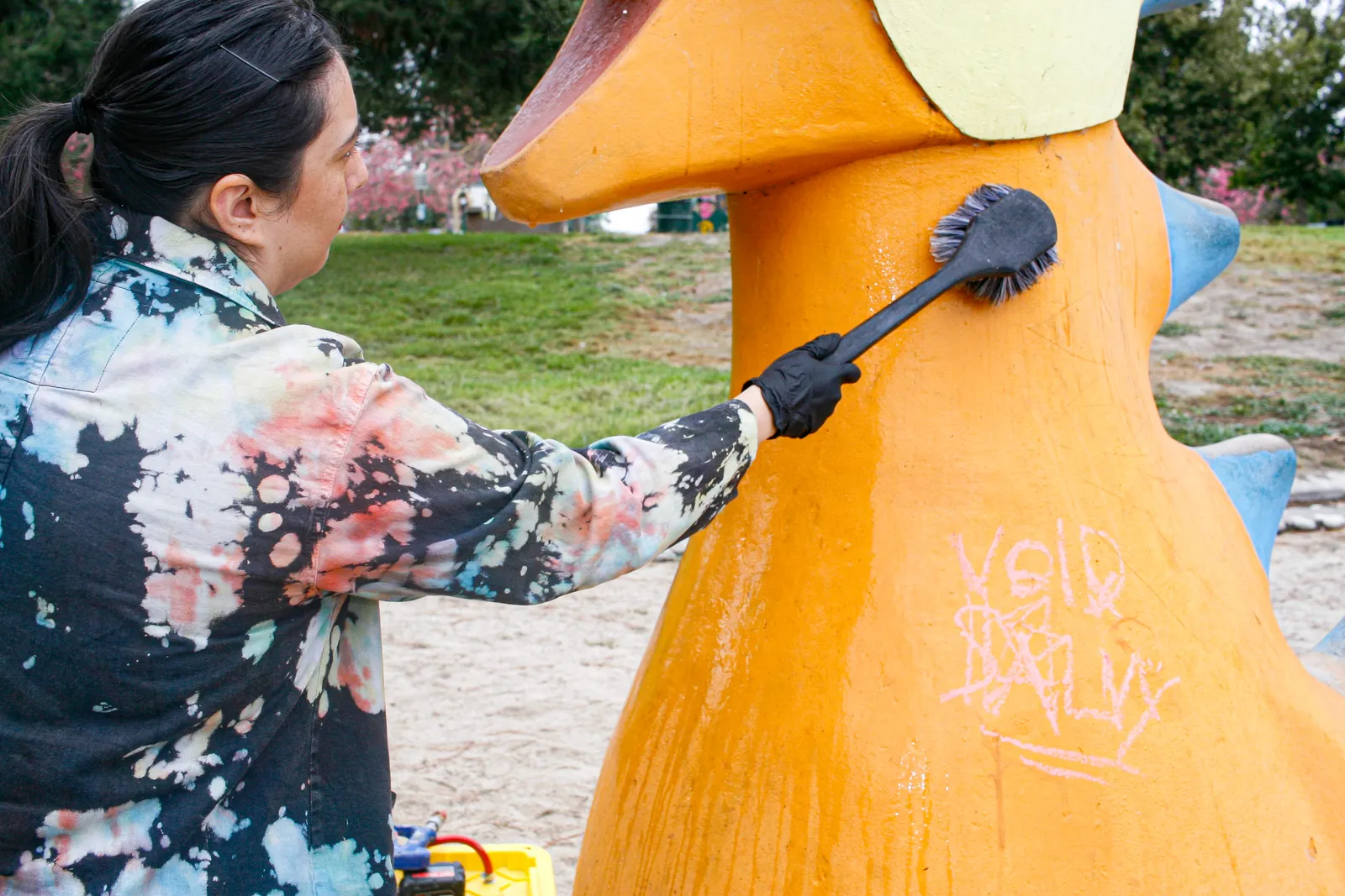 Jennifer Payan applying the protective coating to the restored play sculptures