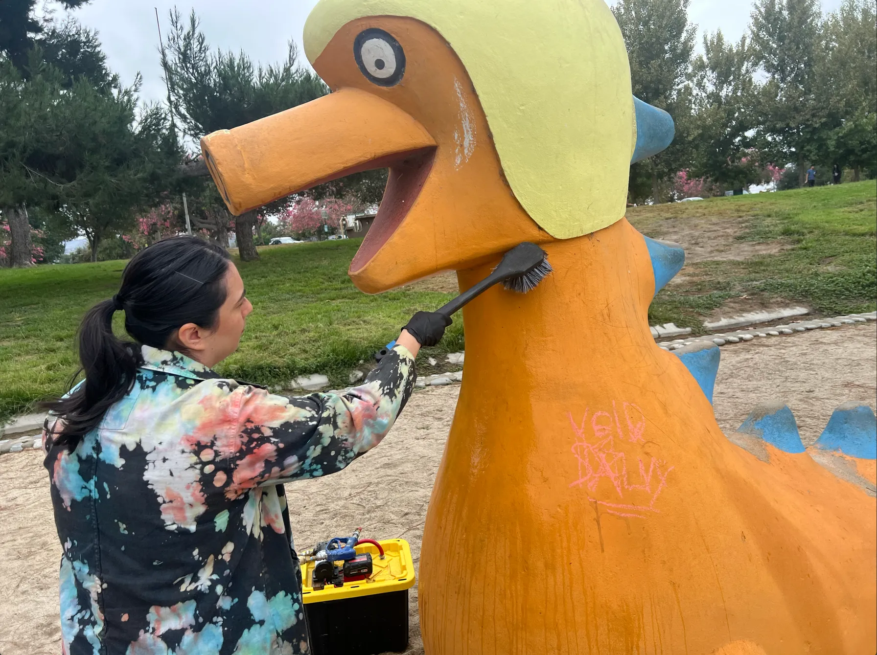 Jennifer using dry brush to clean loose debris from sculpture
