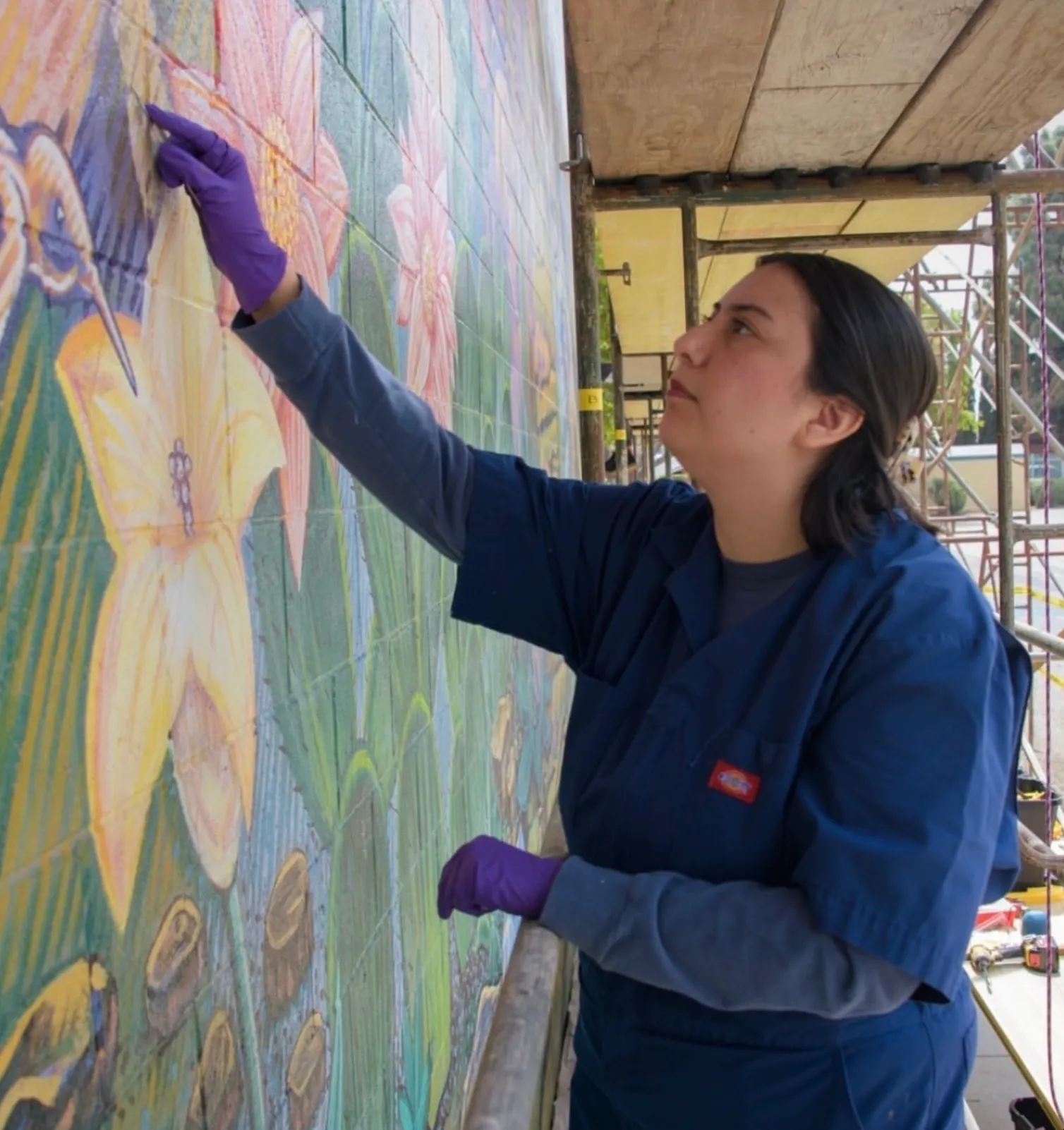 Jennifer on scaffolding working on her section of the mural